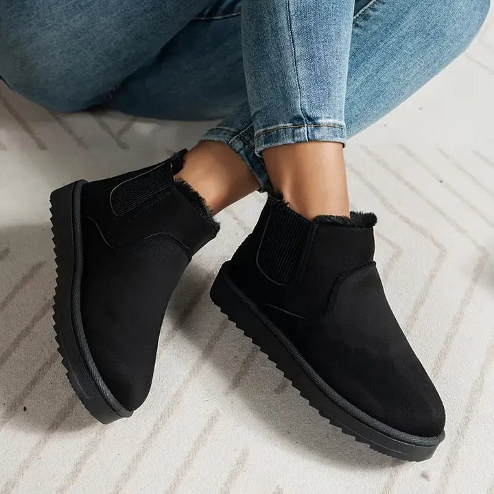 Close-up of the ankle-height cut and smooth exterior of the solid color short boots