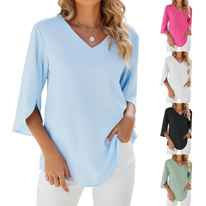 Lifestyle shot of a woman in a blue V-neck blouse outdoors on a warm sunny day