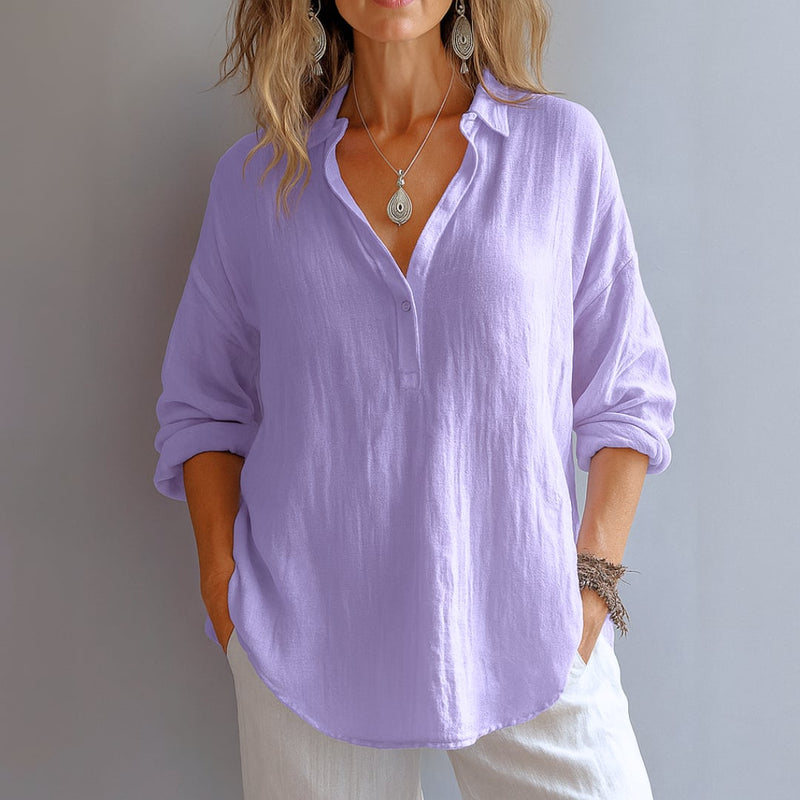 Side profile of a woman in a breezy V-neck blouse, showing the clean silhouette and timeless cut