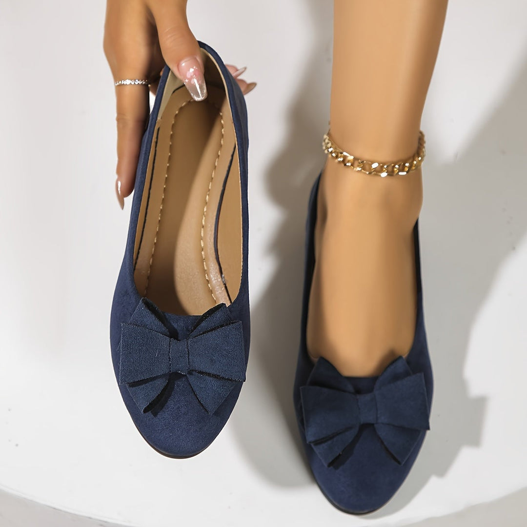 Close-up of bow detail on gray suede-look ballet flat