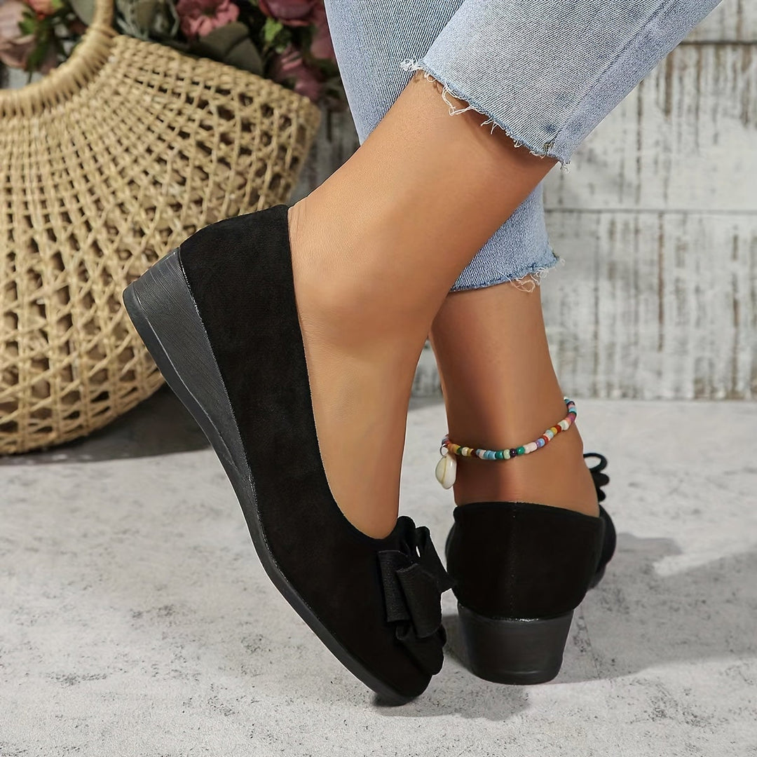 Close-up of bow detail on brown suede-look ballet flat toe