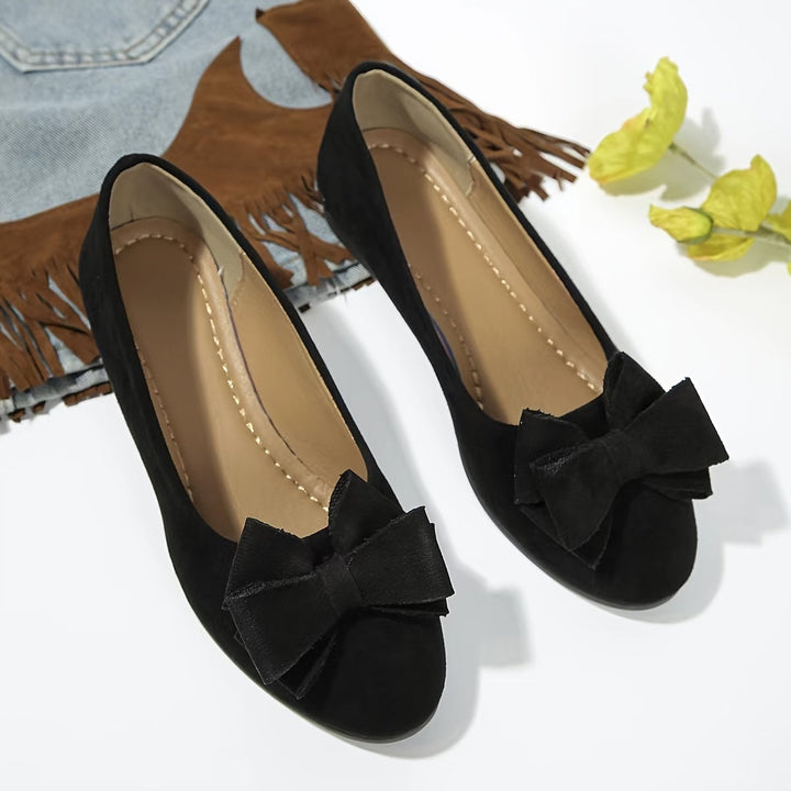 Close-up of Bella ballet flat on foot highlighting bow and round toe