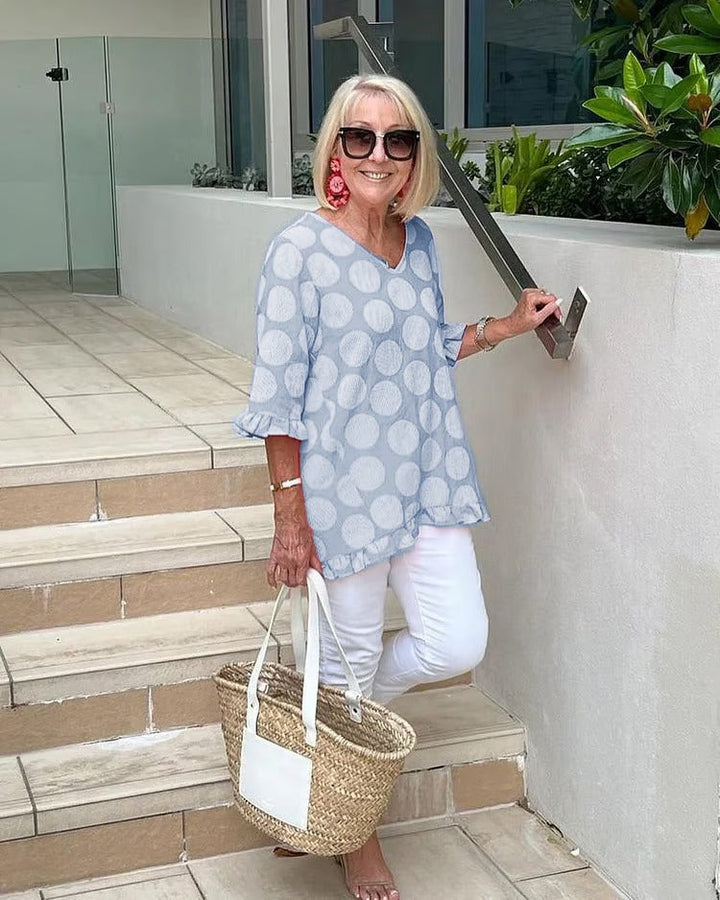 Flat lay of the Beth V-neck blouse in lemon yellow highlighting the timeless polka dot pattern