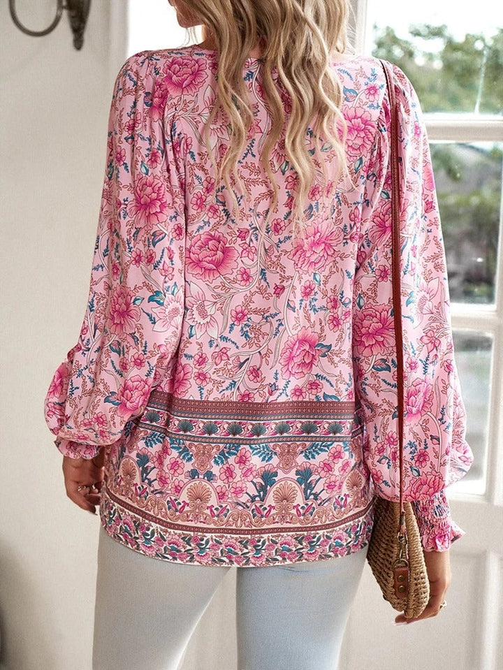 Model wearing a blue summer floral top styled with casual bottoms outdoors