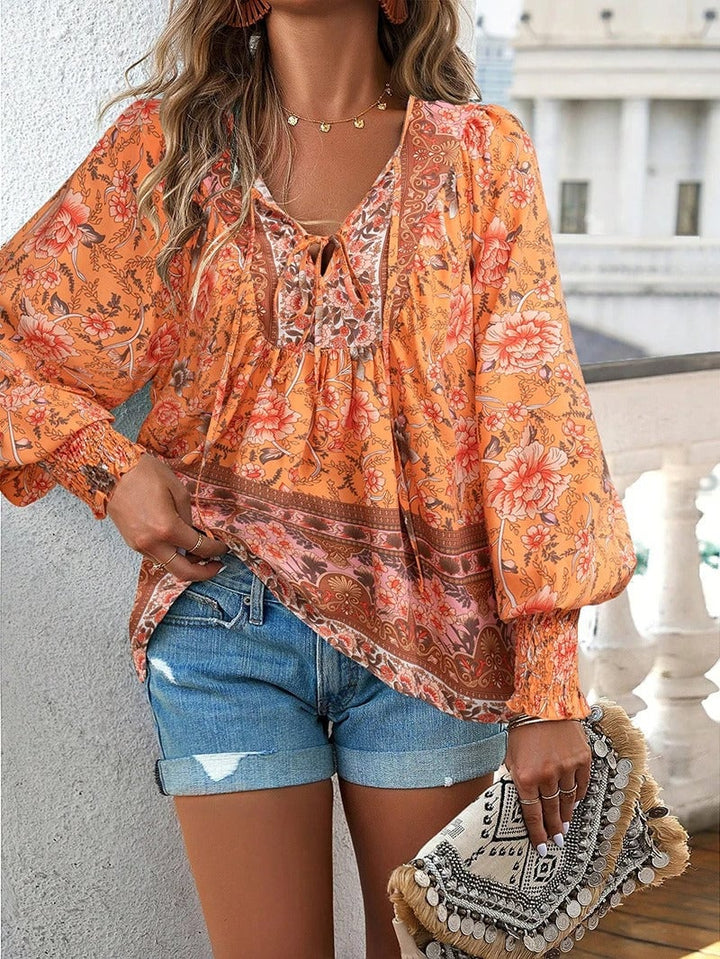 Model in green floral top walking outdoors showing the relaxed carefree fit in motion