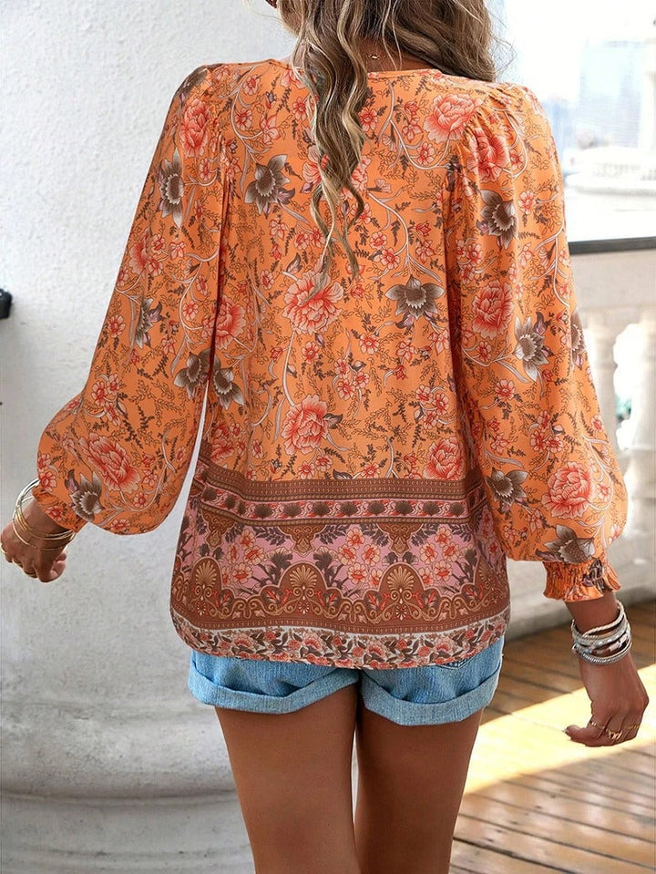 Full-length shot of model wearing the orange summer floral top styled with sandals and accessories
