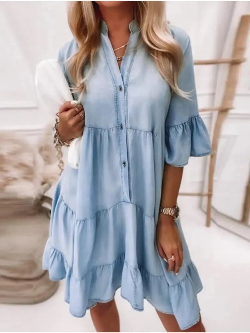 Front view of the Billie tiered ruffle mini dress in light blue chambray with partial button-down neckline and flared sleeves