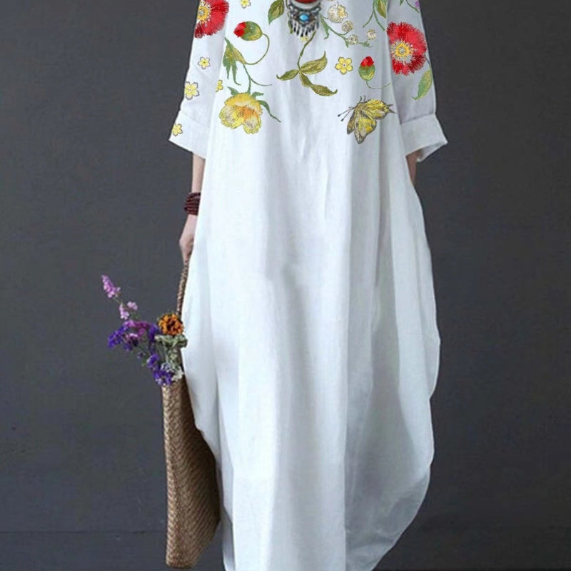 Woman wearing a white floral flowy draped maxi dress with a relaxed, flattering silhouette