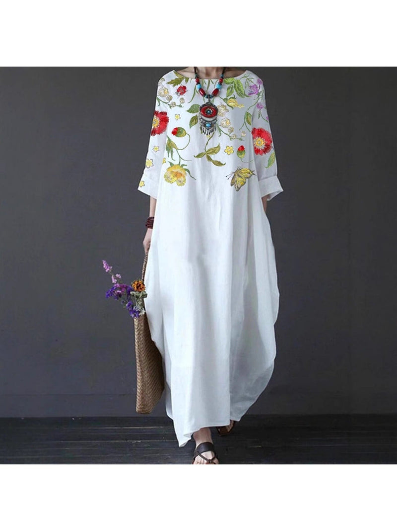 Close-up of the delicate floral print on the white draped maxi dress