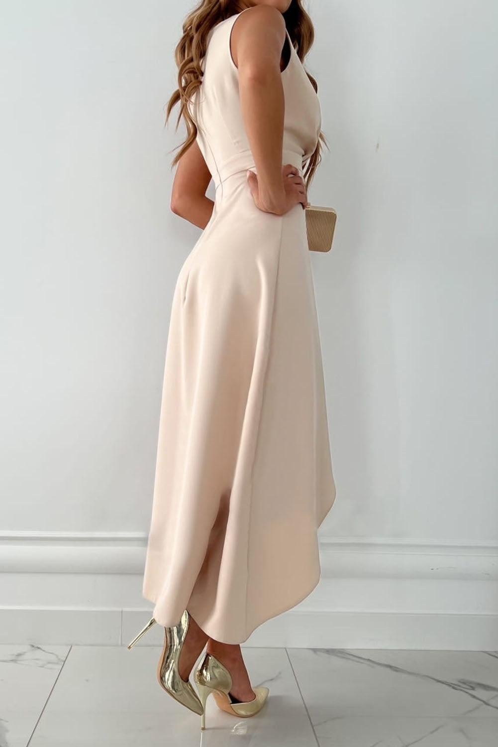 Close-up of the beige wrap dress showing the V-neckline and flowing midi length