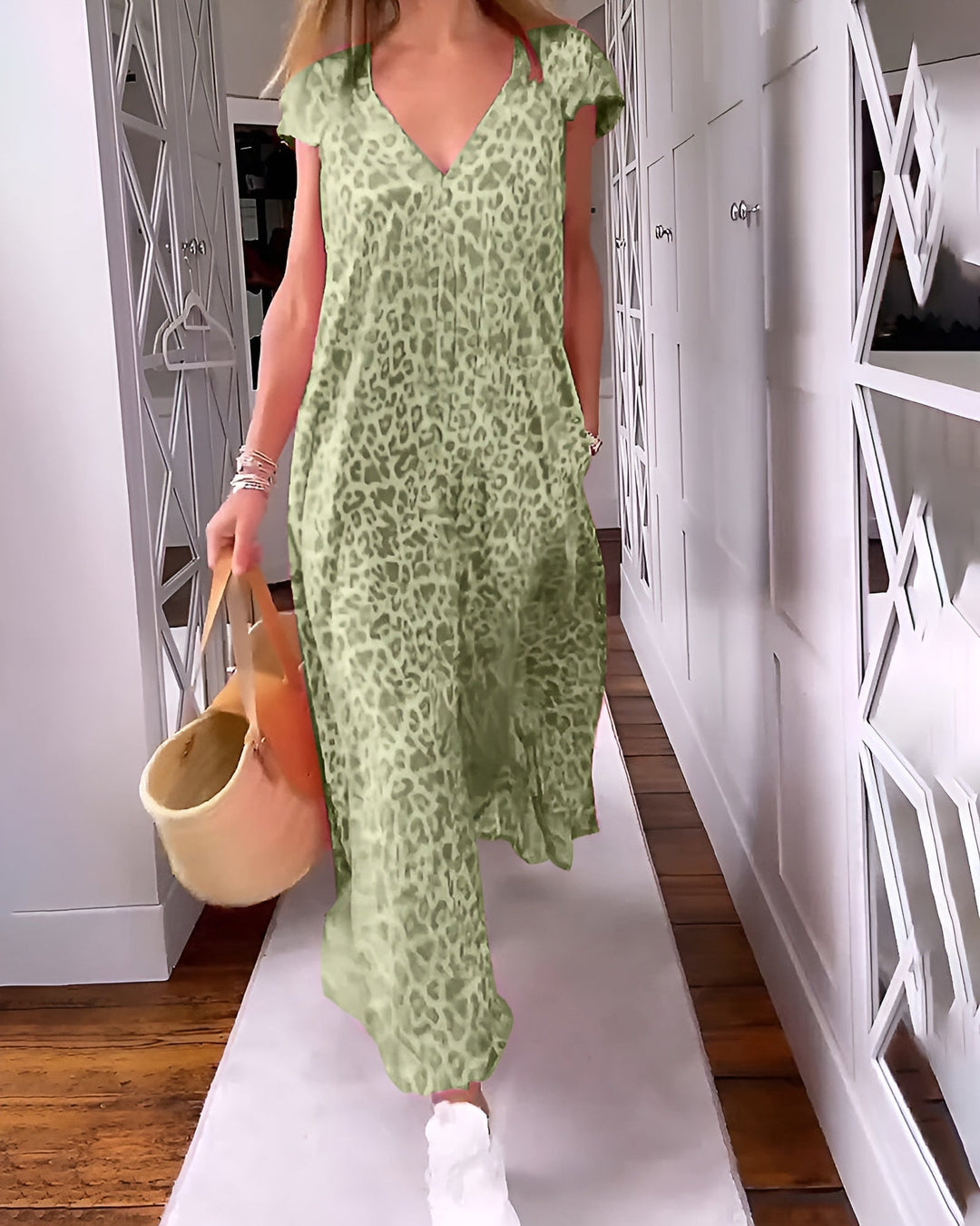 Woman in a green V-neck printed long dress standing in a lifestyle setting, full-length view