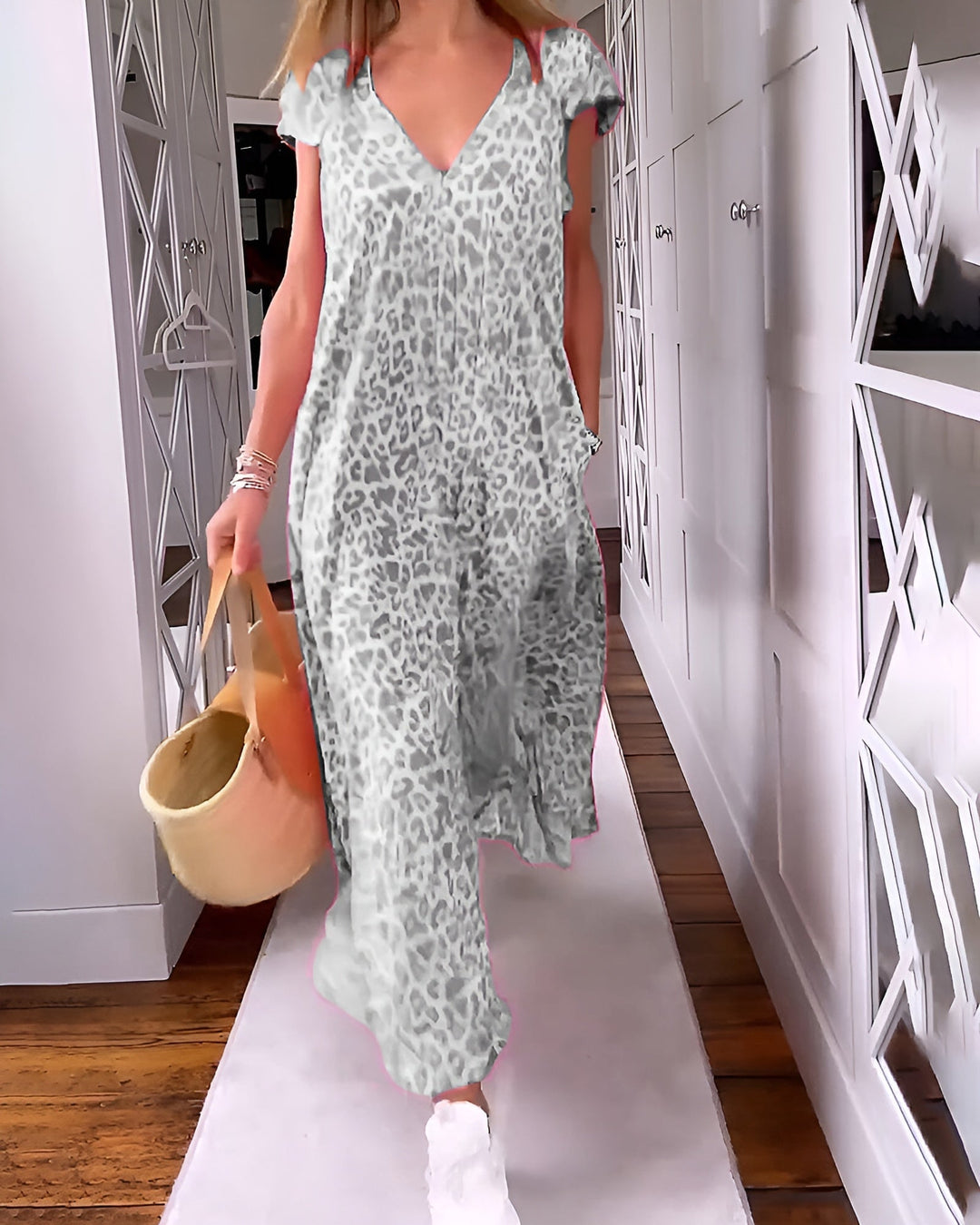 Side profile of a woman wearing a loose short-sleeve printed maxi dress highlighting the elongated silhouette