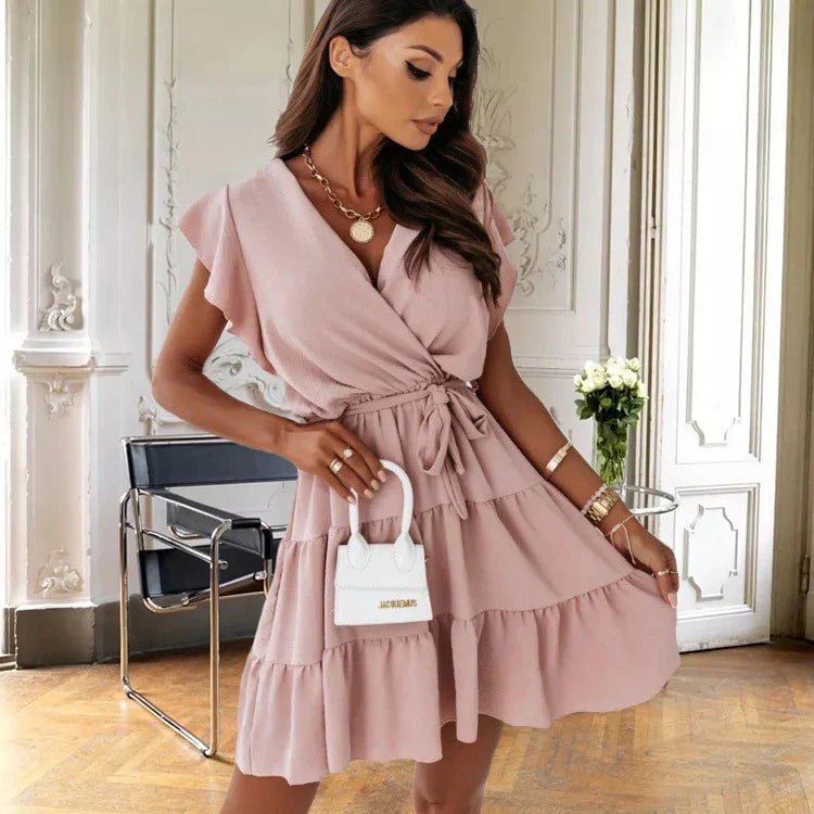 Woman in the Blossom red wrap mini dress with flutter sleeves styled with strappy heels