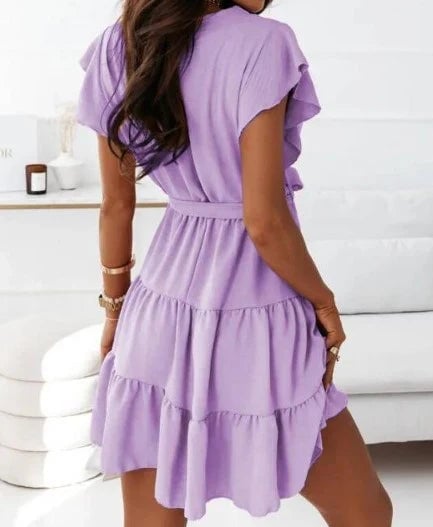 Woman wearing the Blossom pink wrap mini dress with flutter sleeves, full-length front view