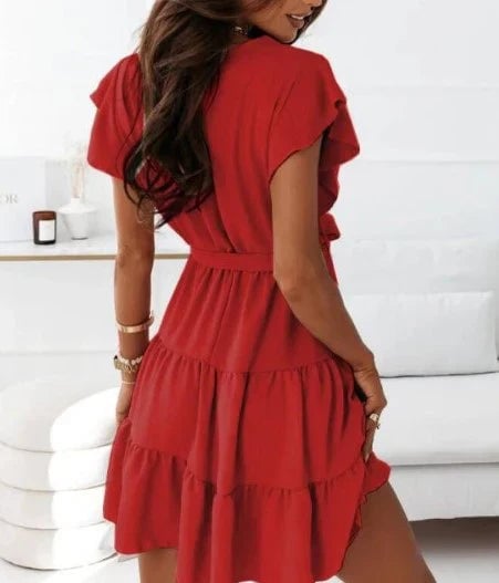 Flat lay of the Blossom wrap mini dress in multiple colors showing ruffle hem and flutter sleeve details