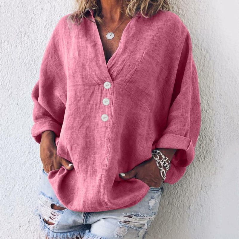 Woman wearing an oversized v-neck long sleeve button-up top in pink with a relaxed drop-shoulder fit