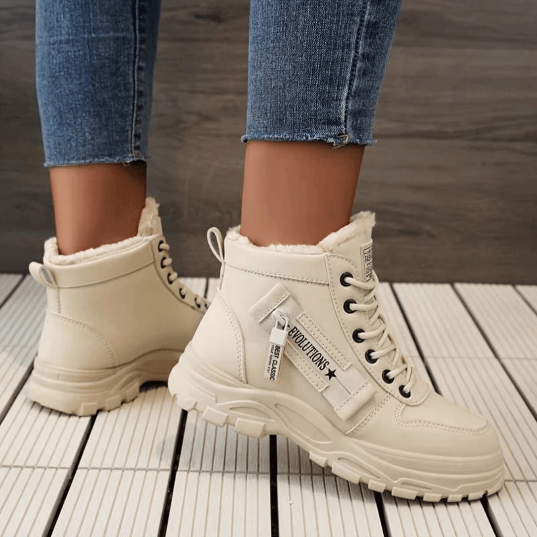 Model wearing women's waterproof winter boots styled with slim jeans and a winter coat
