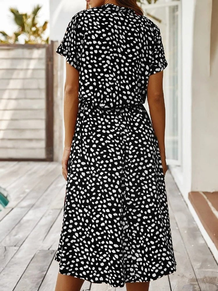 Full-length lifestyle shot of the Brenda summer dress worn outdoors in a summer setting