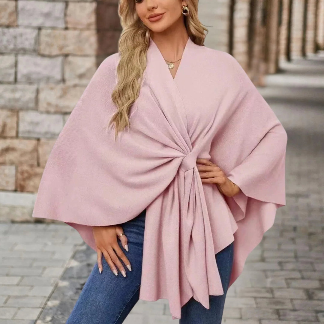 Model wearing an elegant draped poncho with a chic front knot in a flowing silhouette