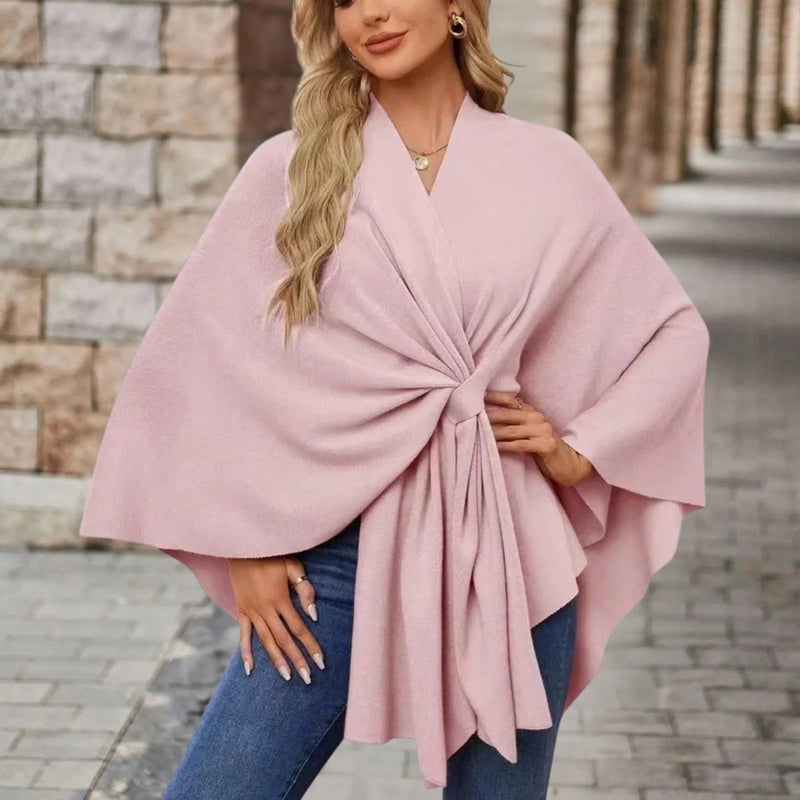 Model wearing an elegant draped poncho with a chic front knot in a flowing silhouette