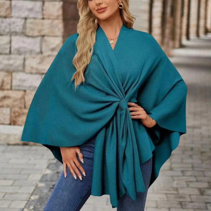 Full-length view of a woman in a draped poncho styled over casual bottoms