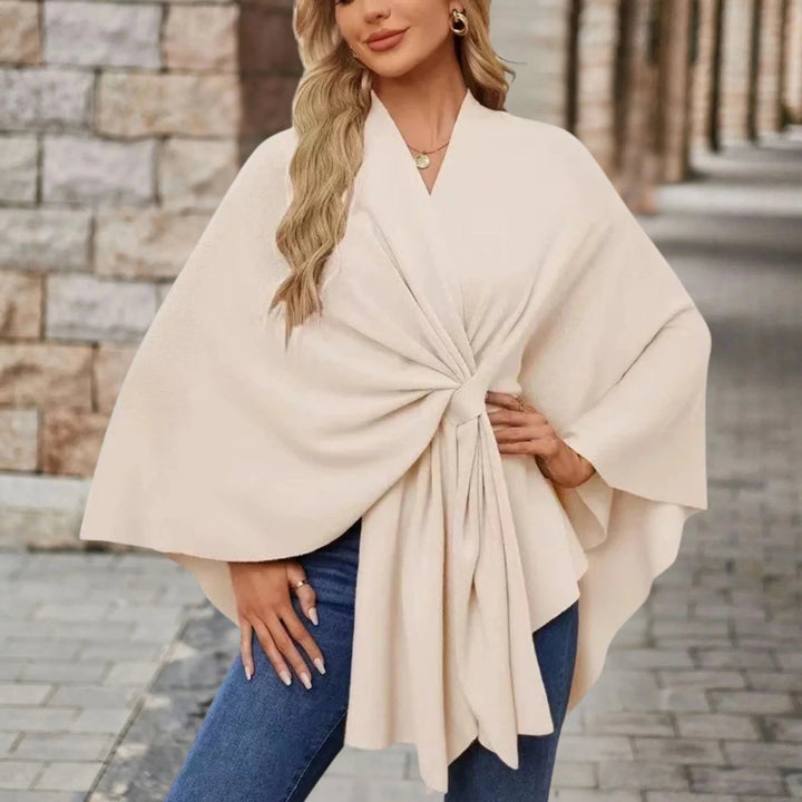 Model styling a draped poncho over jeans for a chic everyday look