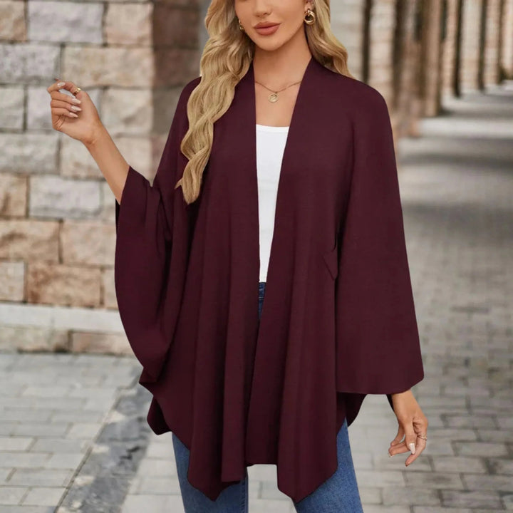 Lifestyle shot of a woman in a cozy draped poncho in an outdoor setting