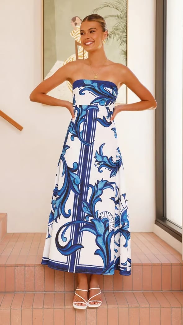 Woman wearing the Briar blue printed wedding guest dress with an elongated tube-style silhouette