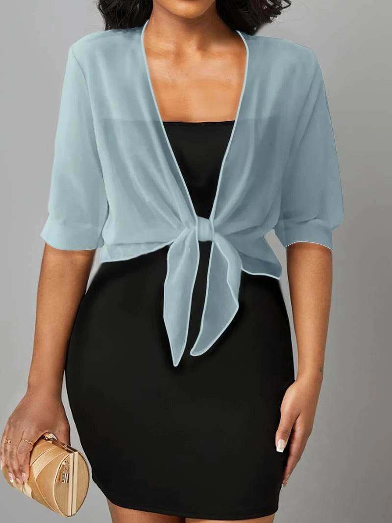 Woman in black sheer tie front blouse with 3/4 sleeves and knotted hem