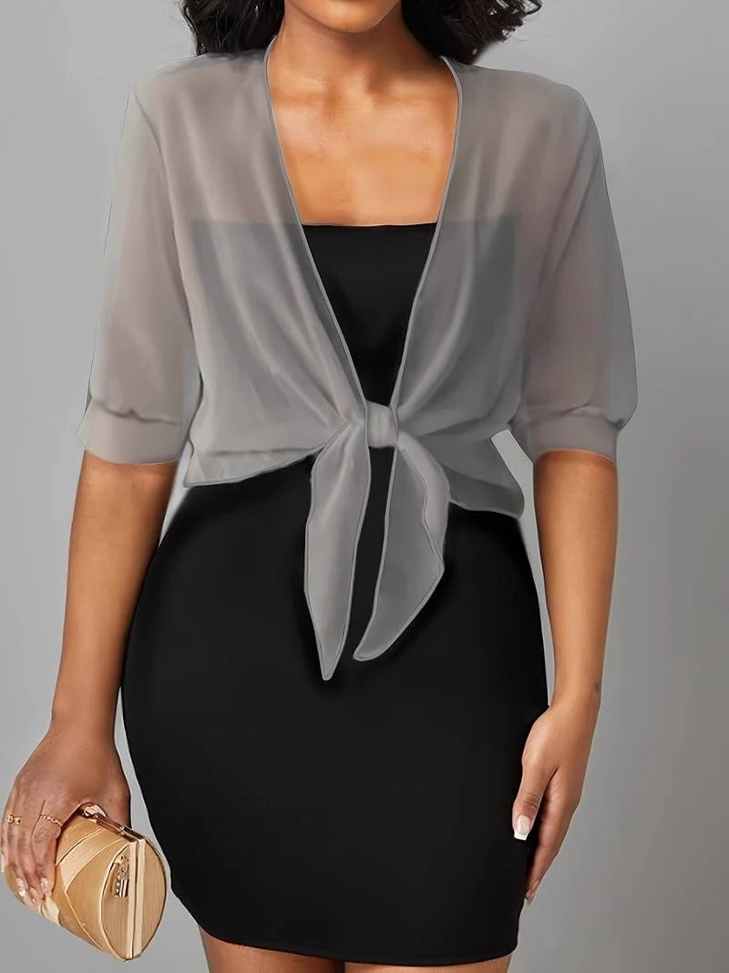 Close-up of roll-tab sleeve detail on the Brisa sheer blouse in black