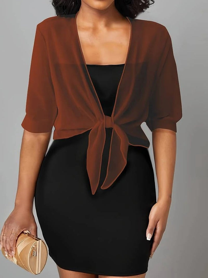 Side view of the Brisa sheer blouse in black showing the relaxed drape