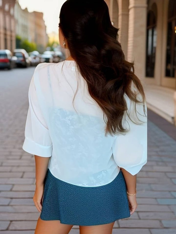 Close-up of the front knot hem detail on the Brisa blouse in red