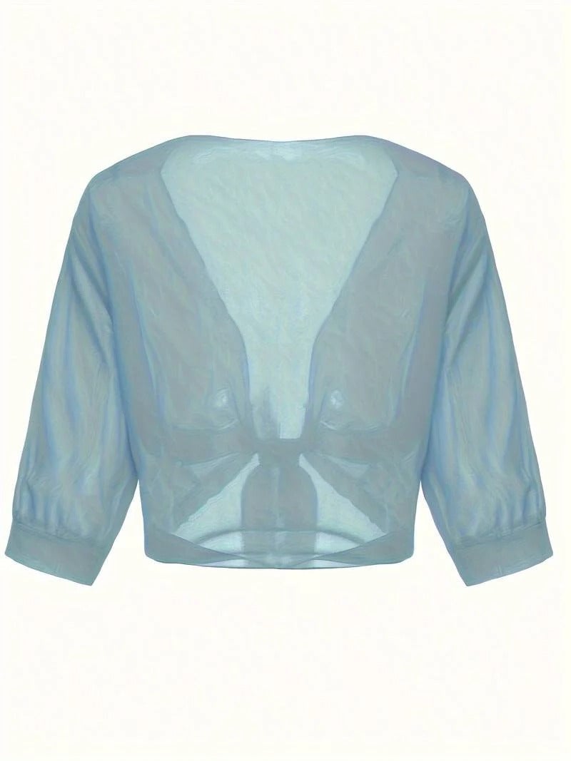 Woman in the Brisa open-front sheer blouse in emerald green with knotted hem