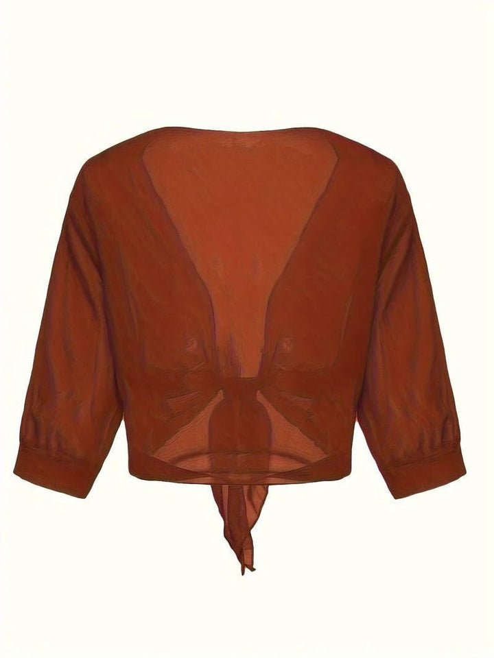 Close-up of the front knot hem detail on the Brisa blouse in light gray