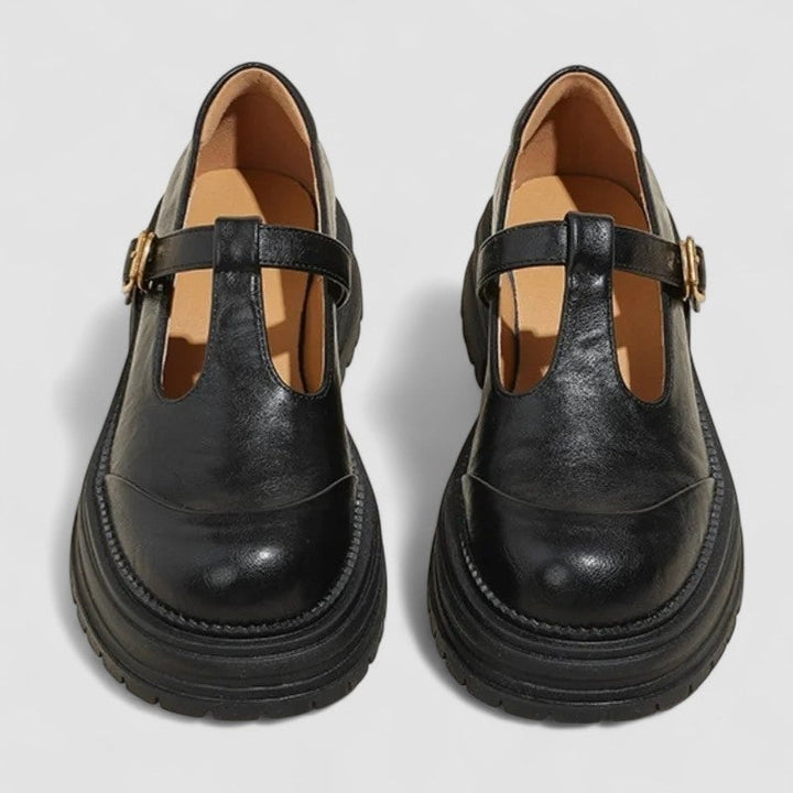Side profile of black orthopedic mary jane shoes showing cushioned sole and strap detail