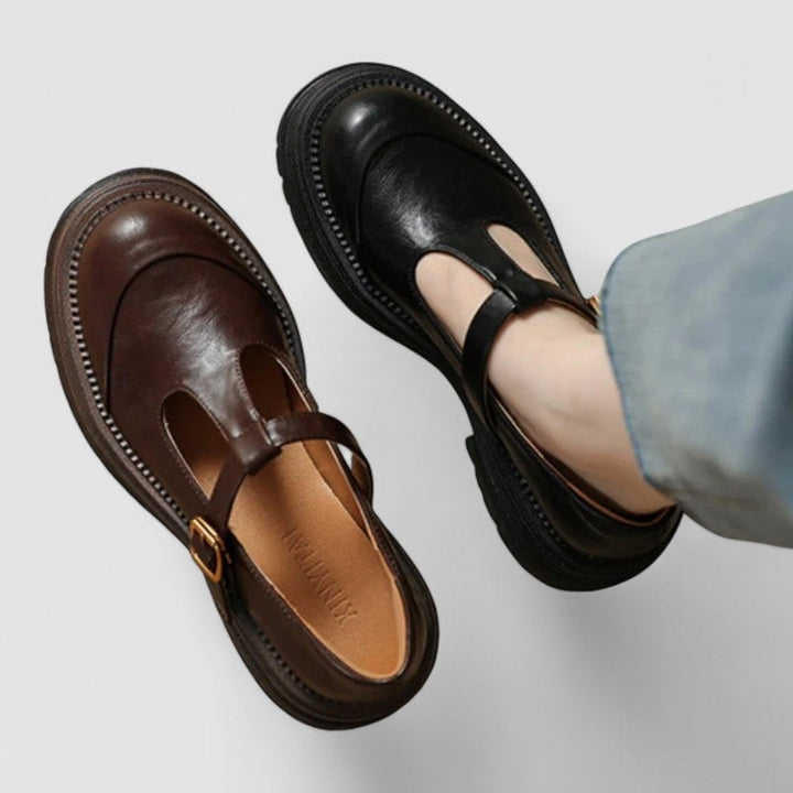 Woman wearing black orthopedic mary jane shoes with tailored trousers on a neutral background