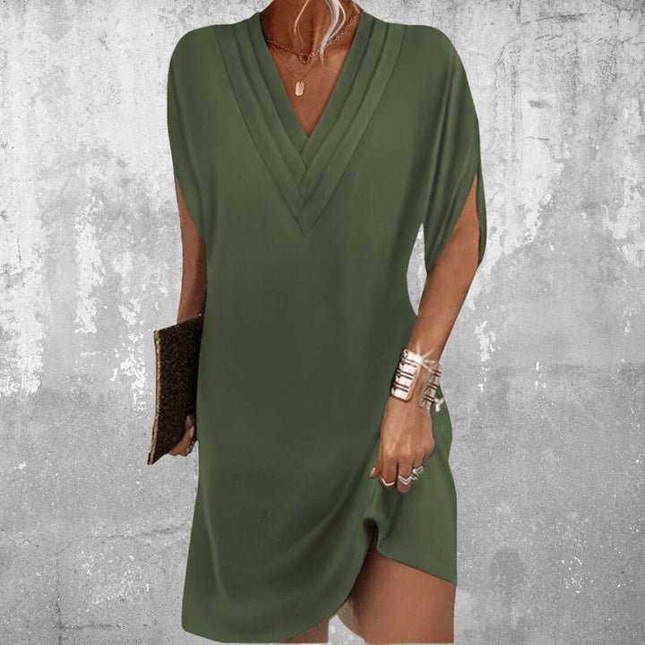 Woman wearing the Brooke elegant tummy covering dress in military green with a flattering V-neckline and sleeve cut-outs