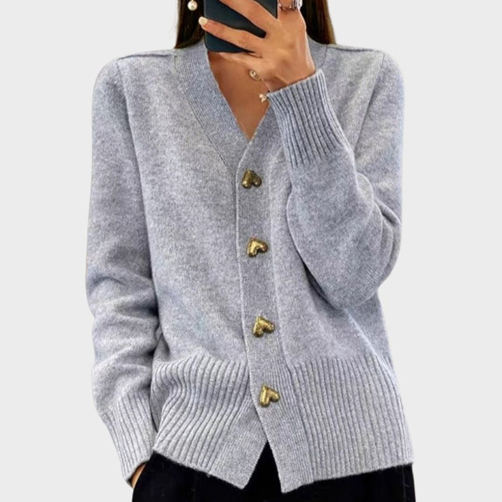 Woman wearing a soft gray heart button cardigan with a flattering relaxed silhouette