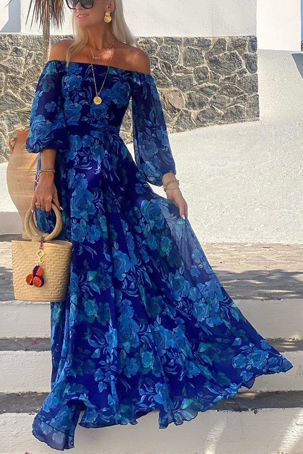 Woman wearing the Brooke blue floral off-shoulder maxi dress in a flowing full-length silhouette outdoors