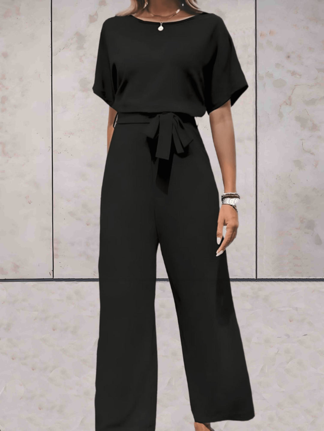 Woman wearing the Cali short-sleeve top and wide-leg pants set in beige with a self-tie waist belt