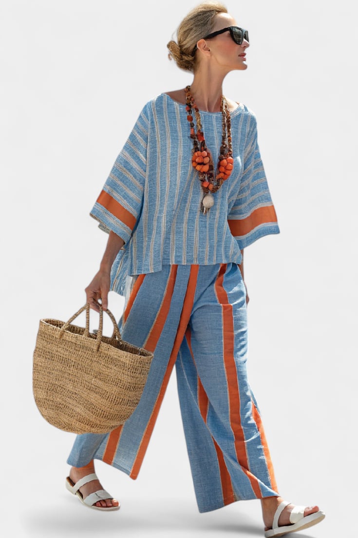 Woman wearing a blue and terracotta striped linen two-piece set with wide-leg palazzo pants and a fringe-hem 3/4-sleeve top, front view
