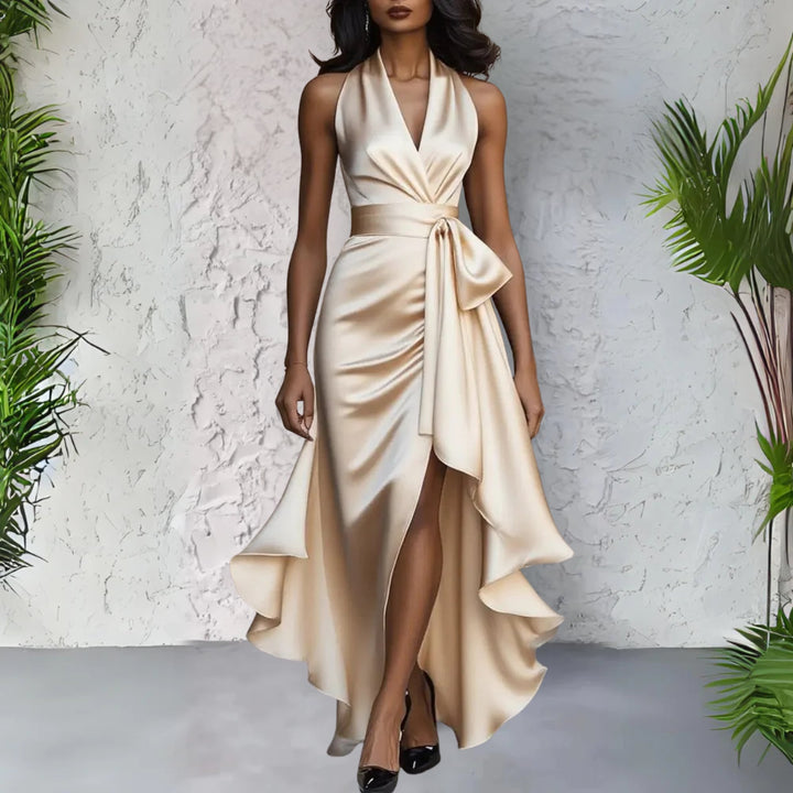 Woman wearing the Calliope navy blue halter neck maxi dress with a wrap waist and flowing floor-length skirt