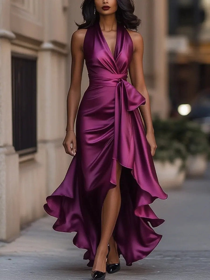 Model wearing the Calliope halter neck maxi dress in navy blue against a neutral background