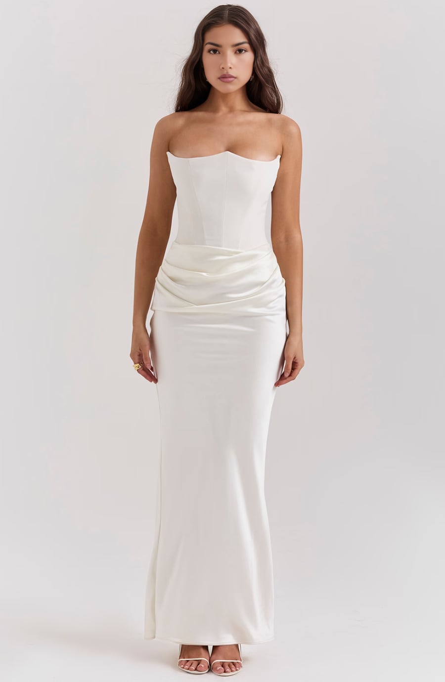 Model in the Camellia strapless evening dress in Brown against a neutral background