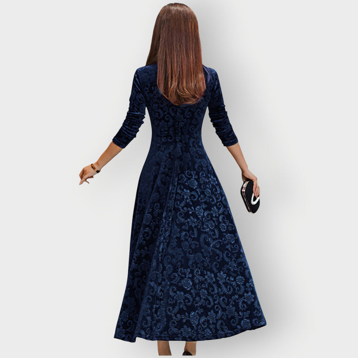 Side profile of woman in red velvet midi dress showing silhouette and sleeve detail