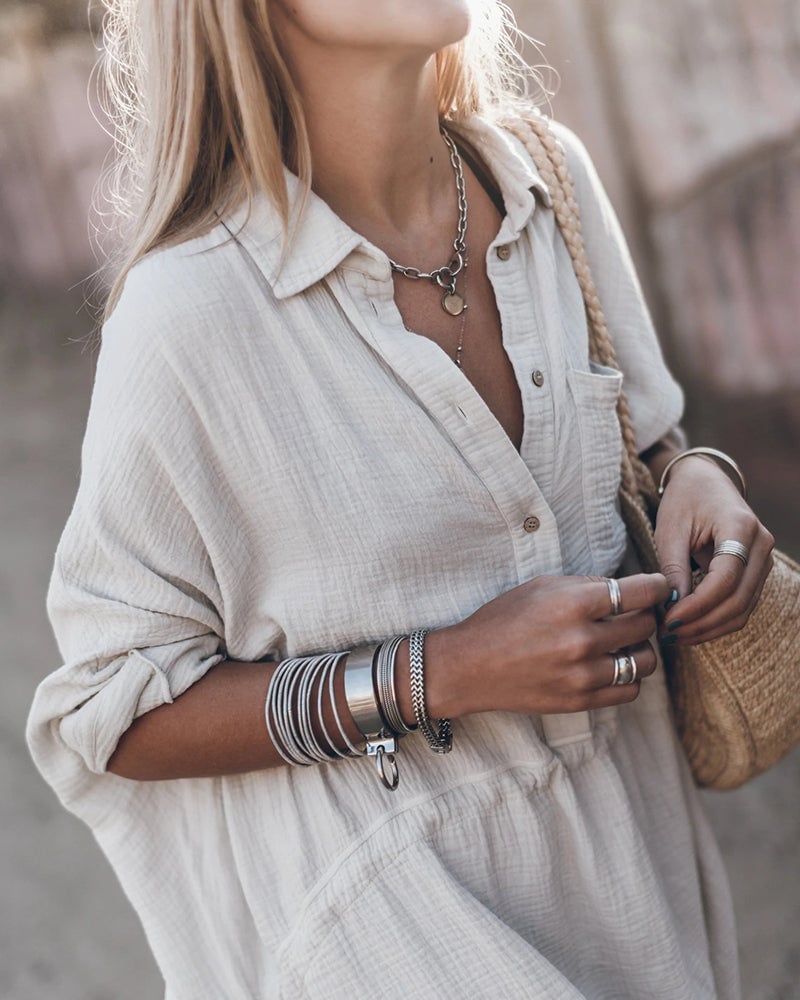 Side view of the white flowy shirt dress highlighting the graceful silhouette and movement