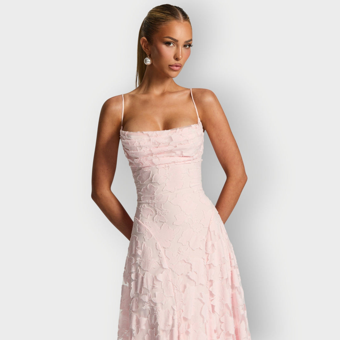 Model twirling in the strapless velvet gown in pink showing movement in the skirt