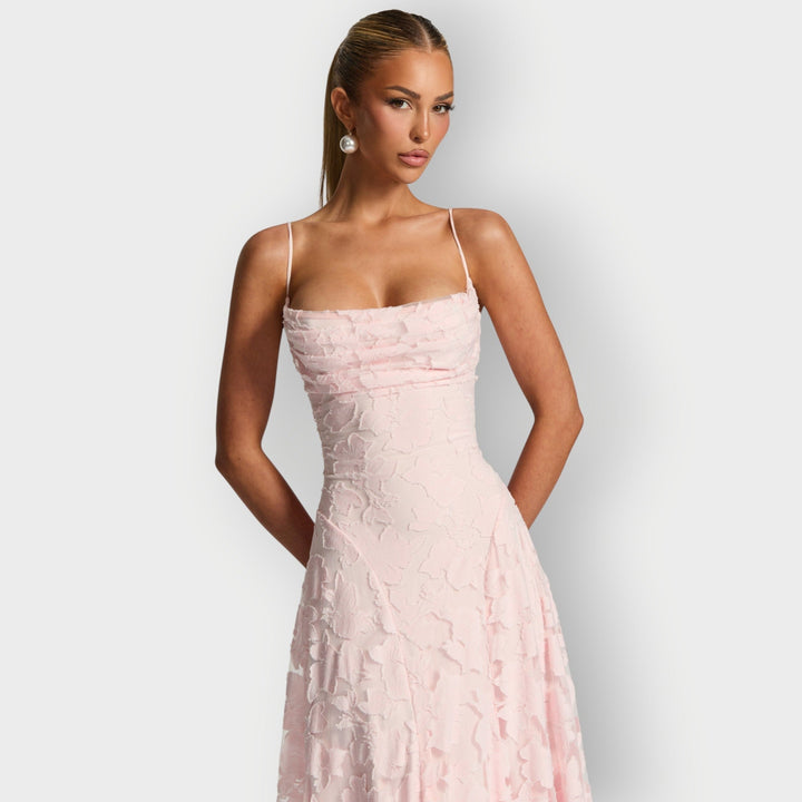 Model twirling in the strapless velvet gown in pink showing movement in the skirt