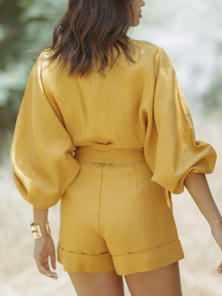 Full-length shot of the yellow linen romper showing the shorts hemline and billowy long sleeves
