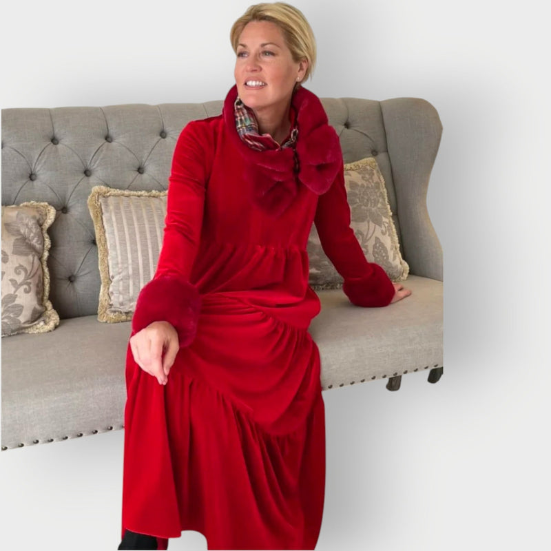 Close-up detail of the Carmen red velvet dress highlighting the rich fabric and refined design accents